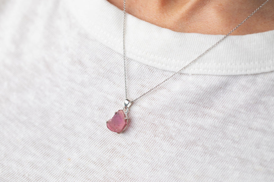 Raw pink tourmaline pendant in sterling silver on a fine chain, worn